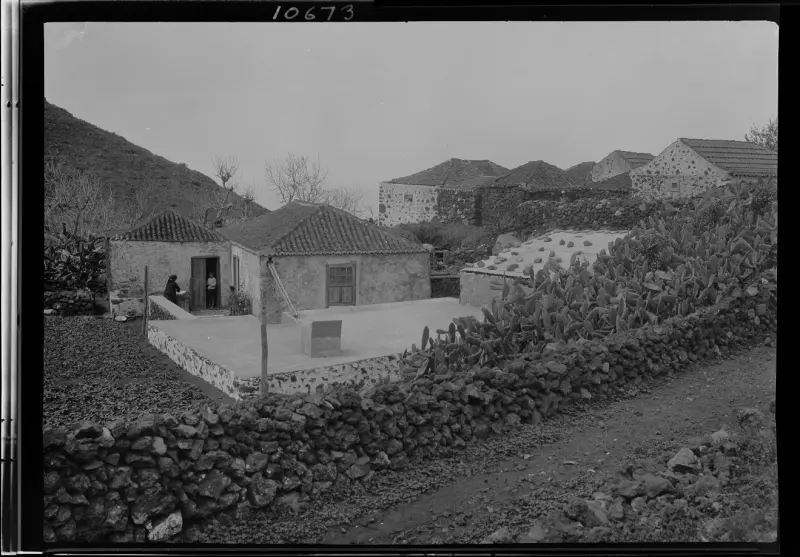 Lateral de una casa de campo con pila de piedra.